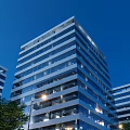 Modern High Rise Residential Building With Glass Curtain Walls And Exterior Night Lighting