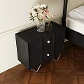 Black Bedside Table with Round Panels Metal Legs and Clear Vase Holding White Pink Flowers
