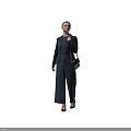 A woman in dark suit with blonde hair carrying small bag standing against black background