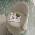 Beige Plush Single Sofa with Open Magazine Featuring Shells on Green Geometric Patterned Floor