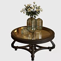 Round Coffee Table With Mirrored Top Dark Carved Legs And Vase With White Flowers