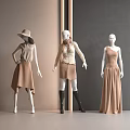 Three Fashion Mannequins in Stylish Beige Brown Outfits with Hat Scarf Black Boots Grey Walls