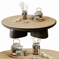 Modern Round Wooden Coffee Table With Black Base Tea Set Vase And Cups On Top