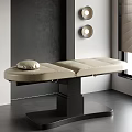 Beige Leather Massage Bed With Pillow On Black Base In Modern Spa Room