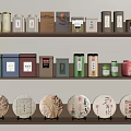 Traditional Tea Sets with Colorful Canisters and Round Tea Cakes on Wooden Shelves