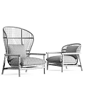 Stylish Pair of Woven Armchairs With Wooden Frames And Soft Neutral Cushions
