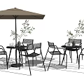 Outdoor Black Metal Table And Chair Set With Beige Umbrella And Plants