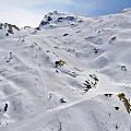 Skiing Scene On Snowy Mountain Slopes With Skiers And Clear Blue Sky