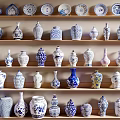 Various Decorative Ceramic Vessels With Diverse Patterns And Shapes On Display Shelves