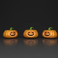 Three Carved Pumpkins With Smiling Faces And Green Stems On Dark Background