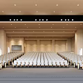 Spacious Conference Room With Wooden Walls Rows Of Seats Projection Screen And Ceiling Lights