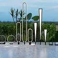 Modern Outdoor Lights In Various Shapes Arranged Near Greenery And Evening Sky