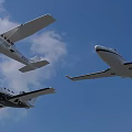 Three Different White Airplanes Flying In Clear Blue Sky With Clouds