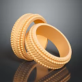 Two Stylish Gold Fashion Rings With Intricate Textured Patterns On Black Surface