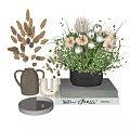 Ceramic Vase With Dried Grass And Black Pot Flower Arrangement On Stacked Books