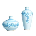 Light Blue Ceramic Vessels with Spiral Patterns Lidded Jar and Tall Vase on White Background