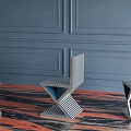 Modern Geometric Single Chair With Black White Stripes Against Blue Paneled Wall And Marble Floor