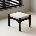 Modern Stool With Black Knobbed Legs And Beige Padded Seat On White Floor