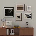 Stylish Photo Wall With Framed Artworks Above Wooden Cabinet Table Lamp Books And Decorative Object