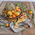 Fresh Mixed Fruits in Wooden Bowl with Melon Tomatoes Starfruit and Leaves on Table