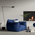 Comfortable Blue Single Sofa with Quilted Design and Fireplace Floor Lamp Green Plant Books