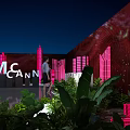 Modern Floral Installation with Pink Lighting Green Plants and Architectural Silhouettes in Night Venue
