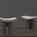 Stools With Curved Beige Cushion And Black Cylindrical Base Against White Blinds And Wooden Floor