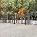 Black Metal Fence With Gates In Outdoor Area Surrounded By Green Trees