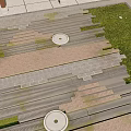 Gray And Brown Stone Slab Ground With Circular Decorative Elements And Green Lawn