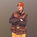 Man In Orange Beanie Patterned Vest Long Sleeve Shirt With Arms Crossed On Gray Background