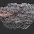 Natural Layered Rock Formation With Dark Brown Textured Surface And Geological Patterns