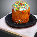 Traditional Sweet Bread With White Frosting And Colorful Sprinkles On Black Plate And White Mat