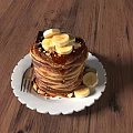 Fluffy Pancake Stack Topped with Banana Slices Nuts Maple Syrup on White Plate Wooden Table