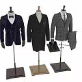 Three Different Style Suits Displayed on Mannequins with Shoes and Trousers Nearby