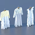 Three Stylish Clothes Hanging On Hangers With Yellow Top And Floral Dresses