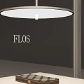 FLOS Round White Pendant Light Hanging Above Modern Table In Showroom Interior