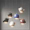 Modern Multicolored Planet Pendant Lights With Rings Hanging Against Gray Wall