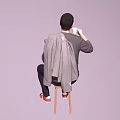 Man sitting on chair holding white cup wearing gray sweater red shirt red shoes