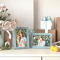 Two Light Blue Photo Frames Displaying Woman Photos With Flower Bouquet Gift Box And Lemons