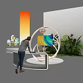 Modern E-commerce Exhibition Booth With Circular Display Colorful Screen Green Plants And Orange Gradient Pillar