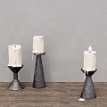Metal Candle Holders With White Candles And Melted Wax On Wooden Table Against Gray Wall