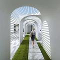 White Arched Pergola With Lattice Design Sunlight Shadows Grass Pathway And Walking Person