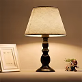 Black Base Table Lamp With Beige Fabric Lampshade White Photo Frame Small Plant Cartoon Figurine