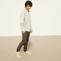 Man In Light Gray Shirt Dark Gray Pants Beige Sneakers In Minimal Space