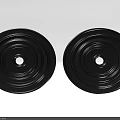 Two Decorative Carved Black Circular Discs With Central Holes And Textured Surfaces