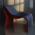 Modern Blue and Red Accent Chair with Curved Design Against Dark Walls and Wooden Floor