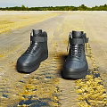 Black High Top Shoes With Laces And Strap On Yellow Textured Surface
