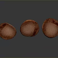 Three Fresh Mushrooms With Brown Caps And Light Stems On Dark Surface