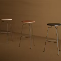 Two Modern Bar Stools With Brown And Beige Seats And Metal Legs Against Brown Wall
