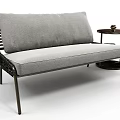 Gray Sofa With Fabric Cushions Metal Frame And Black Three Tier Side Table With Books